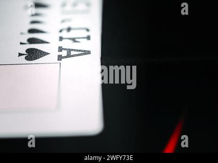 Cette image capture un gros plan d'un as de pique à jouer avec un arrière-plan flou, mettant l'accent sur le symbole emblématique du pique Banque D'Images