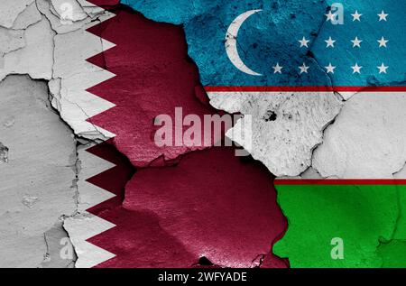 Drapeaux du Qatar et de l'Ouzbékistan peints sur mur fissuré Banque D'Images