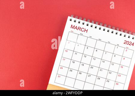 Calendrier de bureau de mars 2024 sur fond de couleur rouge. Banque D'Images