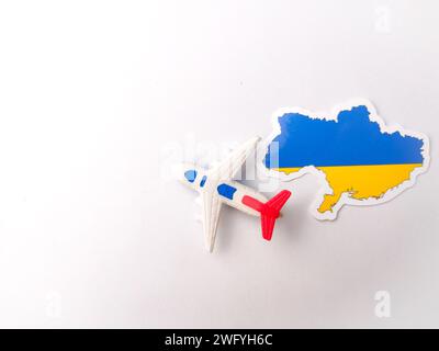 Vue de dessus drapeau de l'ukraine et avion de jouets sur fond blanc. Banque D'Images