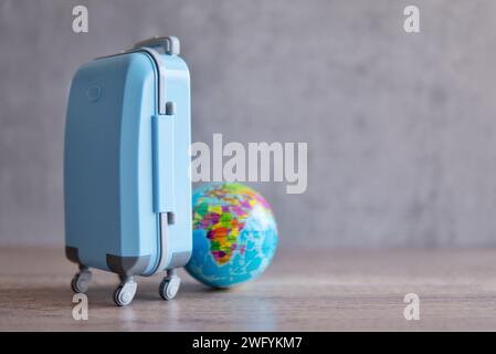 Un bagage bleu sur une table en bois à côté d'un globe. Copier l'espace pour le texte. Concept de voyage et de vacances. Banque D'Images