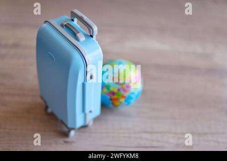 Un bagage bleu sur une table en bois à côté d'un globe. Copier l'espace pour le texte. Concept de voyage et de vacances. Banque D'Images