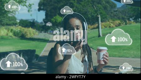 Image de nuages avec des flèches sur une femme parlant sur un smartphone dans un parc Banque D'Images