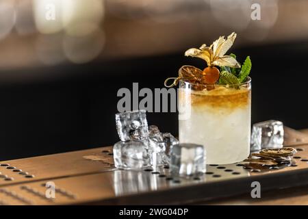 Cocktail exotique Mai Tai décoré de physalis et de menthe sur le comptoir du pub. Banque D'Images