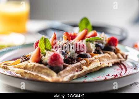 Gaufres maison avec fraises, framboises et crème fouettée. Banque D'Images