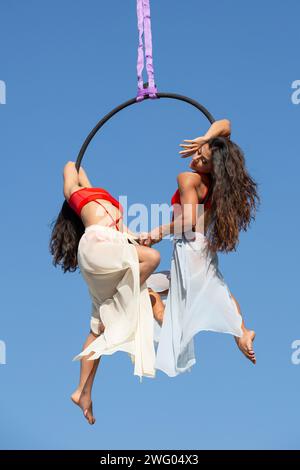 Deux belles gymnastes aériens jouant sur le cerceau à l'extérieur Banque D'Images