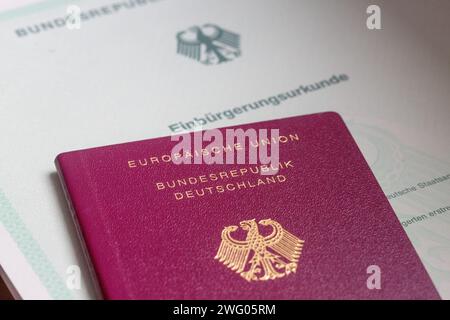 Berlin, Allemagne. 02 février 2024. Un certificat de naturalisation de la République fédérale d'Allemagne et un passeport allemand reposent sur une table. La Chambre d'État s'occupe également de la réforme de la loi sur la citoyenneté adoptée par le Bundestag à la mi-janvier. À l'avenir, les gens pourront se naturaliser plus rapidement en Allemagne et conserver leur passeport étranger. Crédit : Fernando Gutierrez-Juarez/dpa/Alamy Live News Banque D'Images