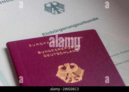 Berlin, Allemagne. 02 février 2024. Un certificat de naturalisation de la République fédérale d'Allemagne et un passeport allemand reposent sur une table. La Chambre d'État s'occupe également de la réforme de la loi sur la citoyenneté adoptée par le Bundestag à la mi-janvier. À l'avenir, les gens pourront se naturaliser plus rapidement en Allemagne et conserver leur passeport étranger. Crédit : Fernando Gutierrez-Juarez/dpa/Alamy Live News Banque D'Images