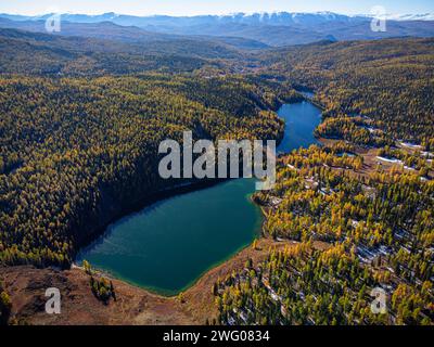 Superbe prise de vue aérienne capturant la beauté sereine d'un lac de montagne entouré de couleurs automnales dans l'Altaï. Banque D'Images