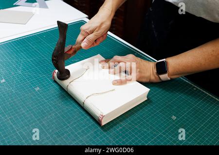 Personne coupant le papier et attachant des clous au tissu Banque D'Images