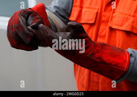 Gilet de sécurité orange portant un gilet rouge blessé Banque D'Images