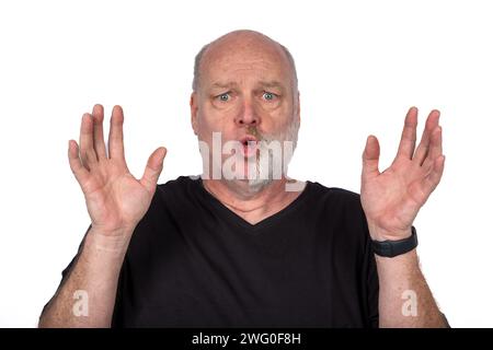 Homme d'âge moyen en T-shirt noir avec expression faciale unique et mains levées, Portrait expressif sur fond blanc - concept de style de vie moderne Banque D'Images