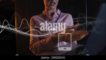 Image du traitement des données et des graphiques sur une femme et un homme divers travaillant sur un ordinateur portable Banque D'Images