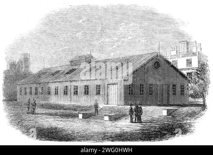 Hangar de forage à Burlington Gardens, [Londres], érigé par les South Middlesex Rifle Volunteers, 1862. Dans notre numéro du 18 janvier dernier, nous avons donné une photo des groupes de fatigue des South Middlesex Rifle Volunteers (régiment de Lord Ranelagh) nivelant le terrain à Burlington Gardens en préparation à l'érection d'un hangar de forage. Nous présentons maintenant à nos lecteurs une vue du hangar que le South Middlesex a érigé. Il est en tôle ondulée, bien construit (par M. Richardson, Euston-Road), et 120ft. long de 50 pi. large, et 11 pieds. jusqu'à l'avant-toit. Il y a des fenêtres dans le toit et sur les côtés qui giv Banque D'Images