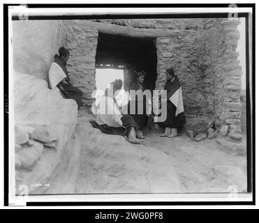 Jeunes filles modestes, c1906. Quatre jeunes femmes Hopi se rassemblent devant une entrée. Banque D'Images