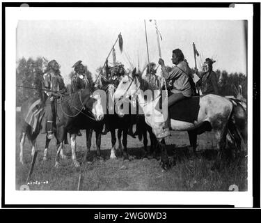 Conseil de guerre, c1908. Six Indiens Crow en pleine régalia, à cheval, Montana.sitting Elk, Medicine Crow, spectacles de poissons, Wolf, deux sifflets Banque D'Images