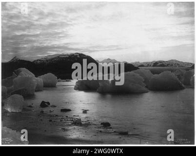 Coucher de soleil de Muir Inlet, Glacier Bay, Alaska, c1899. Grandes formations de glace dans l'eau ; montagnes en arrière-plan. Banque D'Images