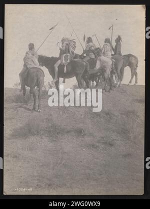 Surplombant la petite corne, 1908. La photographie montre cinq Indiens Crow, Wolf, Fish shows (portant une coiffe), What Way, Lone Tree, et deux sifflets sur le cheval portant des staff. Banque D'Images