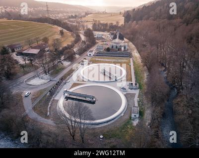 Tir par drone d'une station d'épuration avec des bassins ronds dans un paysage doux au crépuscule, Nagold, Forêt Noire, Allemagne Banque D'Images