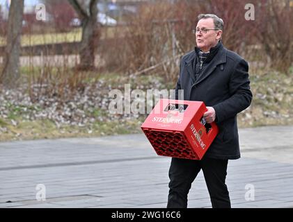 02 février 2024, Thuringe, Erfurt : Bodo Ramelow (Die Linke), ministre-président de Thuringe, emporte une caisse de bière après avoir visité le camp des agriculteurs de l'Association des Thuringe devant le Parlement de l'État de Thuringe. Le vice-président de l'Association des agriculteurs de Thuringe avait fait un pari avec le ministre de l'Agriculture de Thuringe pour une caisse de bière, perdue et avait remis le pari à Ramelow. En marge de la session de trois jours du Parlement de l'État de Thuringe, les agriculteurs demandent l'annulation de la réduction du diesel agricole, une exonération fiscale pour les biocarburants et une réduction Banque D'Images