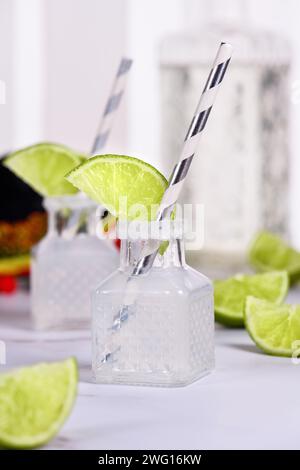 Cocktail alcoolisé classique Margarita. Servi dans des mini-bouteilles de sel et de citron vert. Une idée originale pour un buffet. Banque D'Images