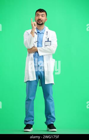 Le docteur, en pleine hauteur, sur fond vert, pense Banque D'Images