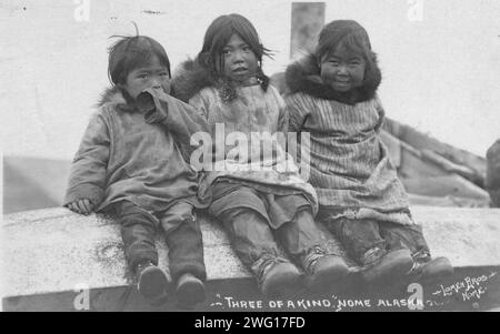 Trois enfants Eskimo assis côte à côte, entre c1900 et c1930. Banque D'Images