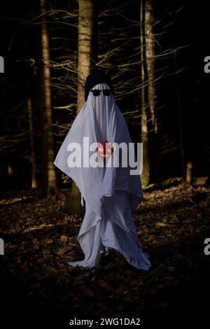 Un enfant dans un drap blanc prétend être un fantôme à Halloween Banque D'Images