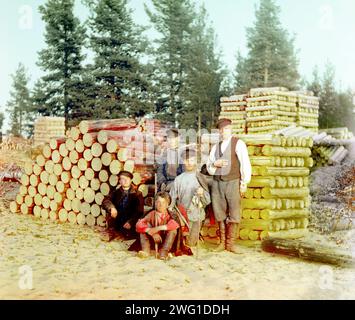 Bûcherons sur la rivière Svir [Empire russe], 1909. De jeunes hommes posèrent devant des piles de rondins, au nord-ouest de la Russie. Le chimiste et photographe russe Sergey Prokudin-Gorsky (1863-1944) fut un pionnier de la photographie couleur qu’il utilisa pour documenter la Russie du début du 20e siècle et son empire, y compris la disparition du mode de vie des peuples tribaux le long de la route de la soie en Asie centrale. Dans une chambre noire de wagon de chemin de fer fournie par le tsar Nicolas II, Prokudin-Gorsky a utilisé le procédé de photographie en trois couleurs pour enregistrer les costumes traditionnels et les occupations, les églises et les mosquées - dont beaucoup sont aujourd'hui classés au patrimoine mondial de l'UNESCO Banque D'Images