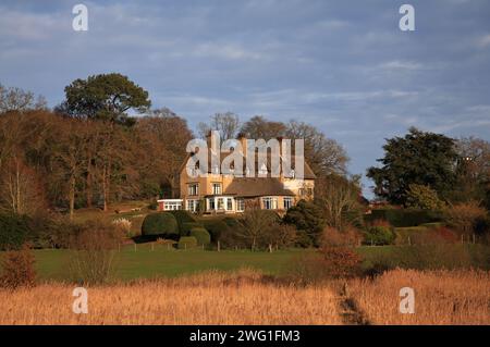 Une vue de How Hill House et des jardins depuis un sentier près de la rivière Ant sur les Norfolk Broads à Ludham, Norfolk, Angleterre, Royaume-Uni. Banque D'Images