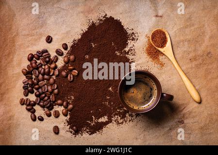 sur le fond rustique, avec vue de dessus, une tasse de café chaud et du café moulu dispersé et des grains torréfiés sur le fond Banque D'Images