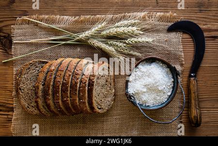 Pain complet tranché avec diverses céréales et graines, farine complète et épis de blé sur toile de jute. vue de dessus. Banque D'Images