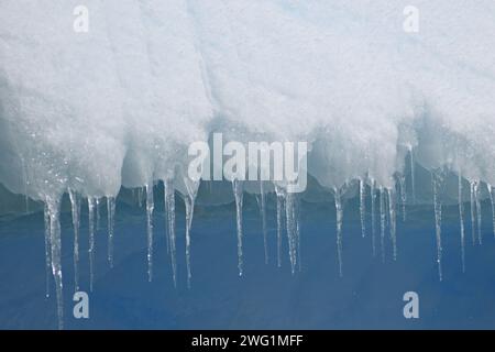 Des glaçons pendent d'un iceberg près de l'île Petermann en Antarctique Banque D'Images