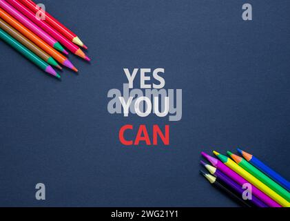 Motivation Oui vous pouvez symboliser. Mots conceptuels Oui vous pouvez sur du beau papier noir. Belle table noire fond noir. Crayons de couleur. Affaires Banque D'Images