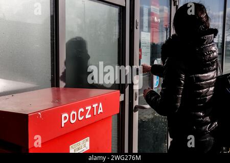 Cracovie, Pologne, 2 février 2024. Une femme entame un bureau de poste avec une boîte postale polonaise dans le centre de Cracovie alors que le PDG de la société du trésor public a été licencié et que la société attend un nouveau PDG. Après le changement de gouvernement en Pologne en décembre 2023, un désaccord de grande ampleur surgit entre les nouveaux dirigeants et l'ancien gouvernement d'extrême droite qui avait le pouvoir pendant 8 ans. Le nouveau gouvernement vise à retirer les PDG de l'ancien gouvernement des institutions cruciales telles que les médias publics et les tribunaux, les entreprises de trésorerie ou les gouvernements régionaux. Crédit : Dominika Zarzycka/Alamy Live News Banque D'Images