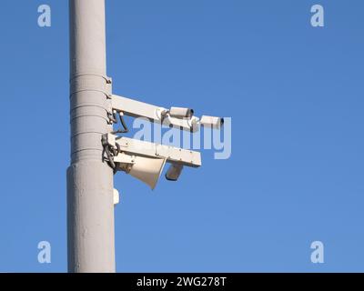 Caméras routières de contrôle de la circulation montées sur le poteau contre le ciel bleu clair sans nuages Banque D'Images