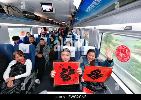 (240202) -- QIANDONGNAN, 2 février 2024 (Xinhua) -- min Deshui (2e R) et long Chunxiang (1e R) montrent le caractère chinois 'Fu', qui signifie 'bonne fortune', à bord du train G4835 le 1 février 2024. Min Deshui et son épouse long Chunxiang originaires de la province du Guizhou du sud-ouest de la Chine travaillent dans le comté de Tonglu de la province du Zhejiang dans l'est de la Chine depuis 11 ans. Jeudi, le couple a commencé son voyage de retour en prenant le train à grande vitesse G4835 de Hangzhou, capitale du Zhejiang, à Kaili dans le Guizhou, ce qui leur a pris moins de huit heures. Après avoir parcouru plus de 1 500 kilomètres par tra Banque D'Images