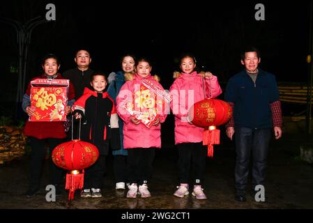 (240202) -- JINPING, 2 février 2024 (Xinhua) -- min Deshui (2e L) et long Chunxiang (4e L) posent pour une photo de famille dans le village de Ladong du comté de Jinping, dans la province du Guizhou, au sud-ouest de la Chine, le 1 février 2024. Min Deshui et son épouse long Chunxiang originaires de la province du Guizhou du sud-ouest de la Chine travaillent dans le comté de Tonglu de la province du Zhejiang dans l'est de la Chine depuis 11 ans. Jeudi, le couple a commencé son voyage de retour en prenant le train à grande vitesse G4835 de Hangzhou, capitale du Zhejiang, à Kaili dans le Guizhou, ce qui leur a pris moins de huit heures. Après avoir parcouru plus de 1 500 kilomètres Banque D'Images