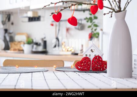 L'intérieur de la cuisine de la maison est décoré de coeurs rouges pour la Saint-Valentin. Décoration sur la table, cuisinière, ustensiles, ambiance festive dans un fari Banque D'Images