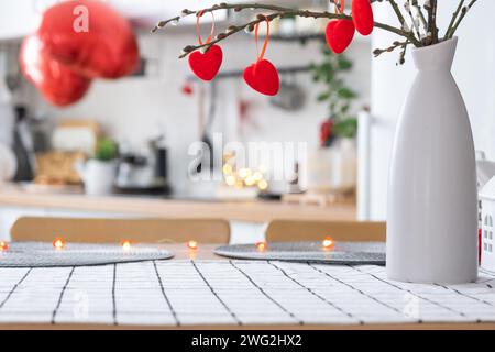 L'intérieur de la cuisine de la maison est décoré de coeurs rouges pour la Saint-Valentin. Décoration sur la table, cuisinière, ustensiles, ambiance festive dans un fari Banque D'Images