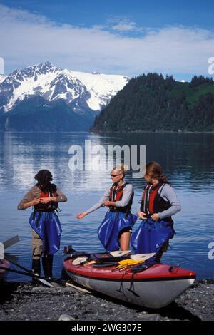 Les kayakistes mettent des gilets de sauvetage et des jupes pulvérisées en préparation pour se diriger vers Resurrection Bay, Miller's Landing, Seward, centre-sud de l'Alaska Banque D'Images