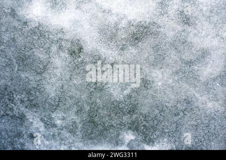 Texture du lac gelé avec beaucoup de fissures sur la surface de la glace. Vue de dessus. Banque D'Images