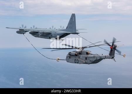 Le CH-53k King Stallion se branche avec succès dans une drogue en forme d'entonnoir remorquée derrière un KC-130J lors de tests de réveil de ravitaillement aérien au-dessus de la baie de Chesapeake. Photo de Dane Wiedmann. (Photo militaire américaine par l'état-major/publiée) Banque D'Images