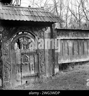 Bucarest, Roumanie, approx. 1980. Une belle porte sculptée traditionnelle du comté de Maramures exposée au National Village Museum. Banque D'Images