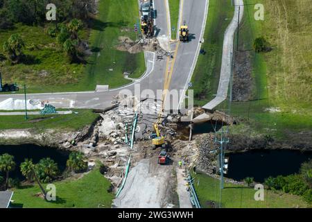 Construction de routes. Excavatrice réparant le pont détruit après que l'ouragan a inondé l'asphalte en Floride. Équipement de construction à Banque D'Images