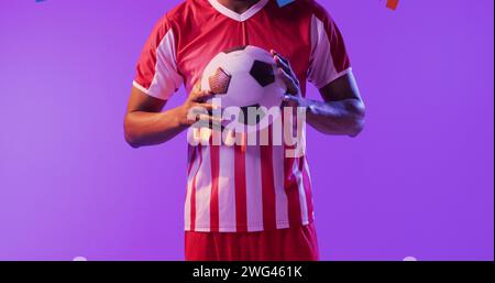 Homme afro-américain tient un ballon de football, avec espace de copie Banque D'Images