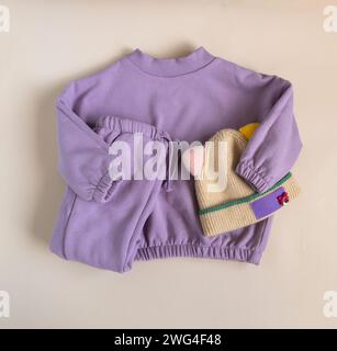 Sweat-shirt chaud pour enfants et joggers avec chapeau drôle sur fond de fuzz pêche. Vêtements d'extérieur élégants pour enfants. Tenue de mode printanière Banque D'Images