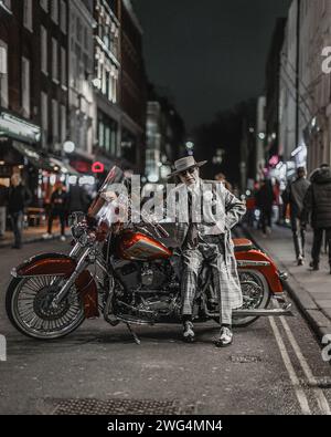 L'artiste George Skeggs pose sur une moto à Soho, Londres. Banque D'Images