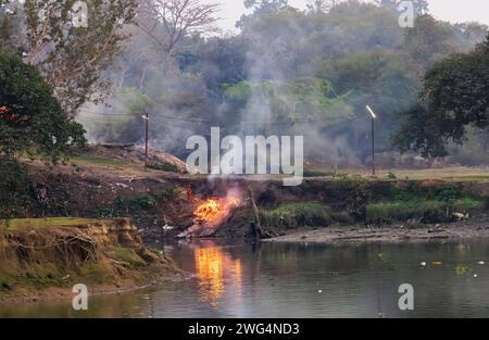 Bûchers de crémation funéraire hindous traditionnels brûlant à Jagaddal Ghat sur les rives de la rivière Hooghly au crépuscule dans le North Barrackpore, Bengale occidental, Inde Banque D'Images