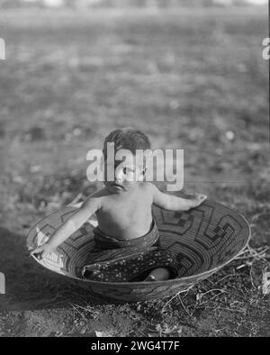 Maricopa enfant, c1907. Maricopa enfant assis dans un grand panier. Banque D'Images